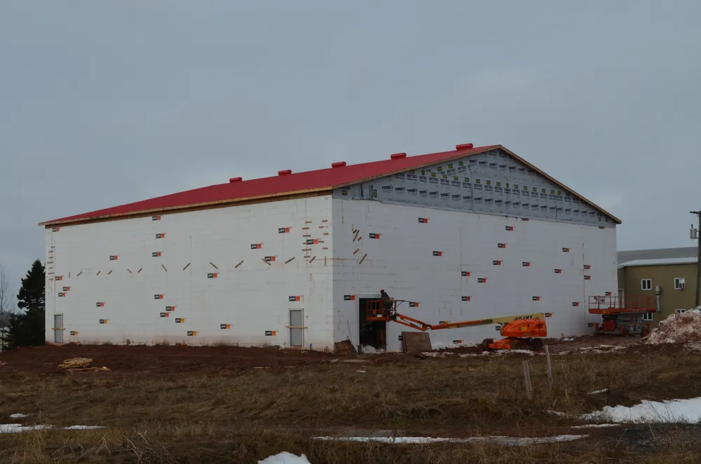 A potato storage building under construction, red roof on