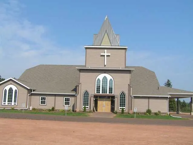 A finished church with a steeple and arched windows